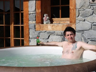 Luxury Chalets Morzine hot tub outdoor man with beer relaxing